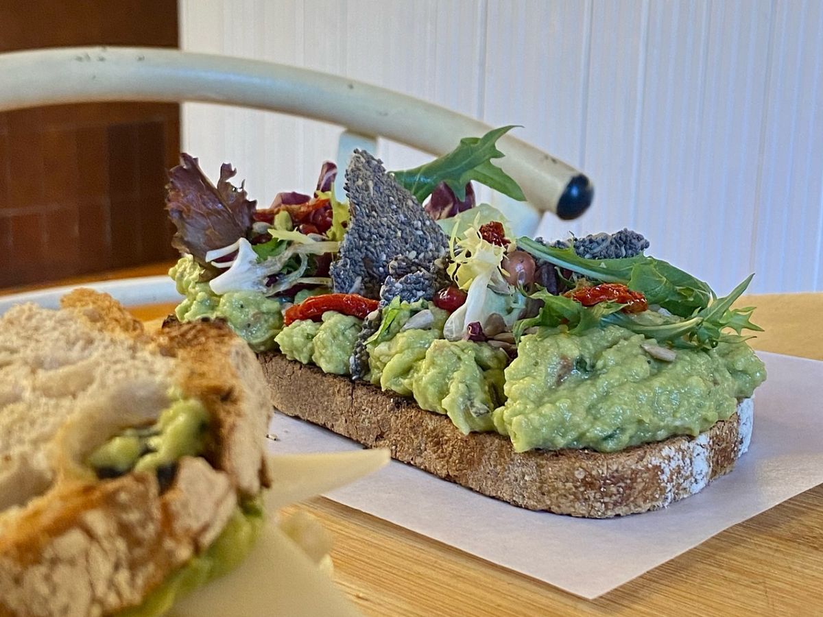Tostada de aguacate con hojas frescas, tomates secos y chips crujientes en Billy Brunch, Barcelona.