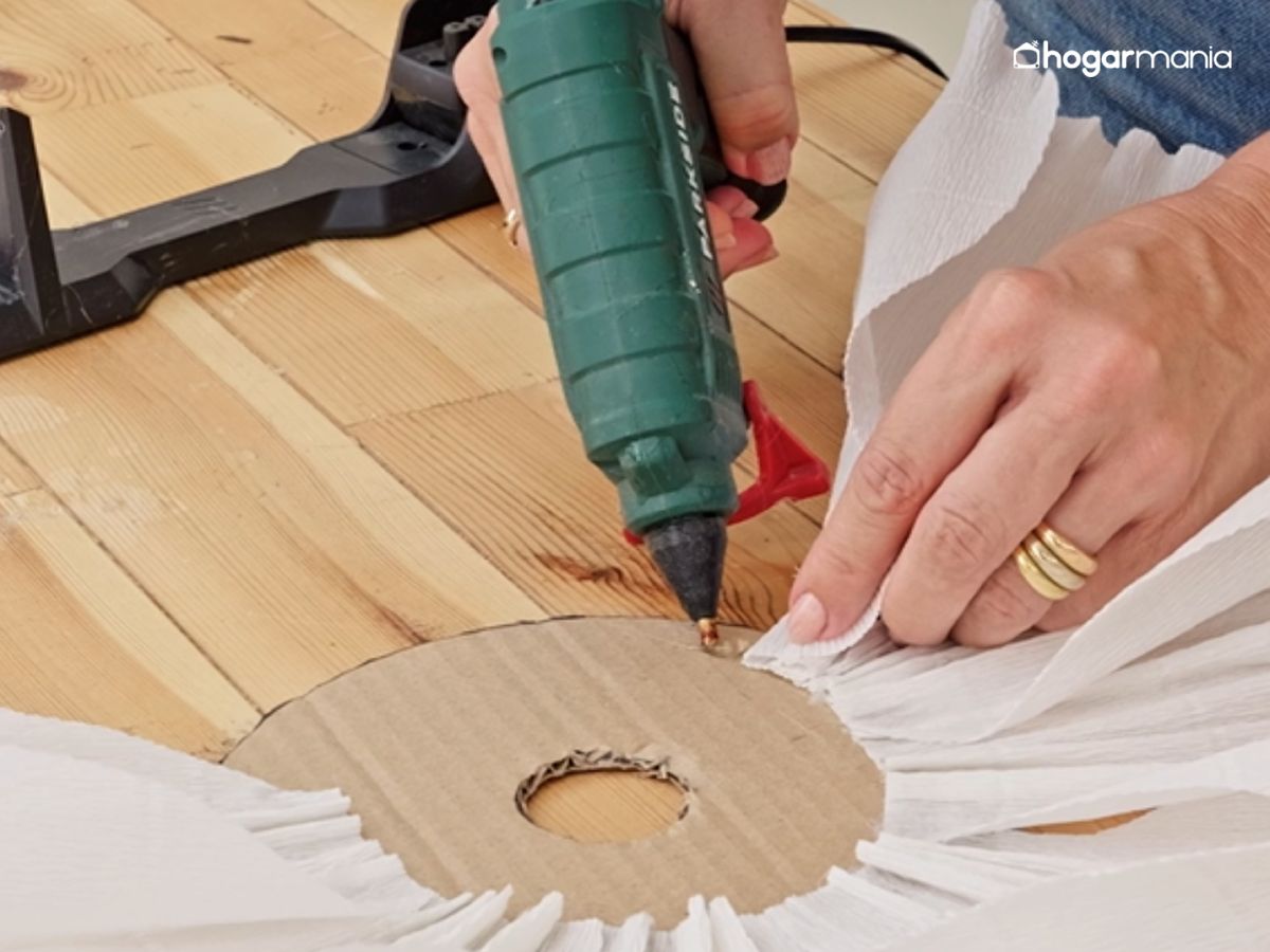 Pegamos los pétalos con silicona caliente alrededor del aro de cartón.