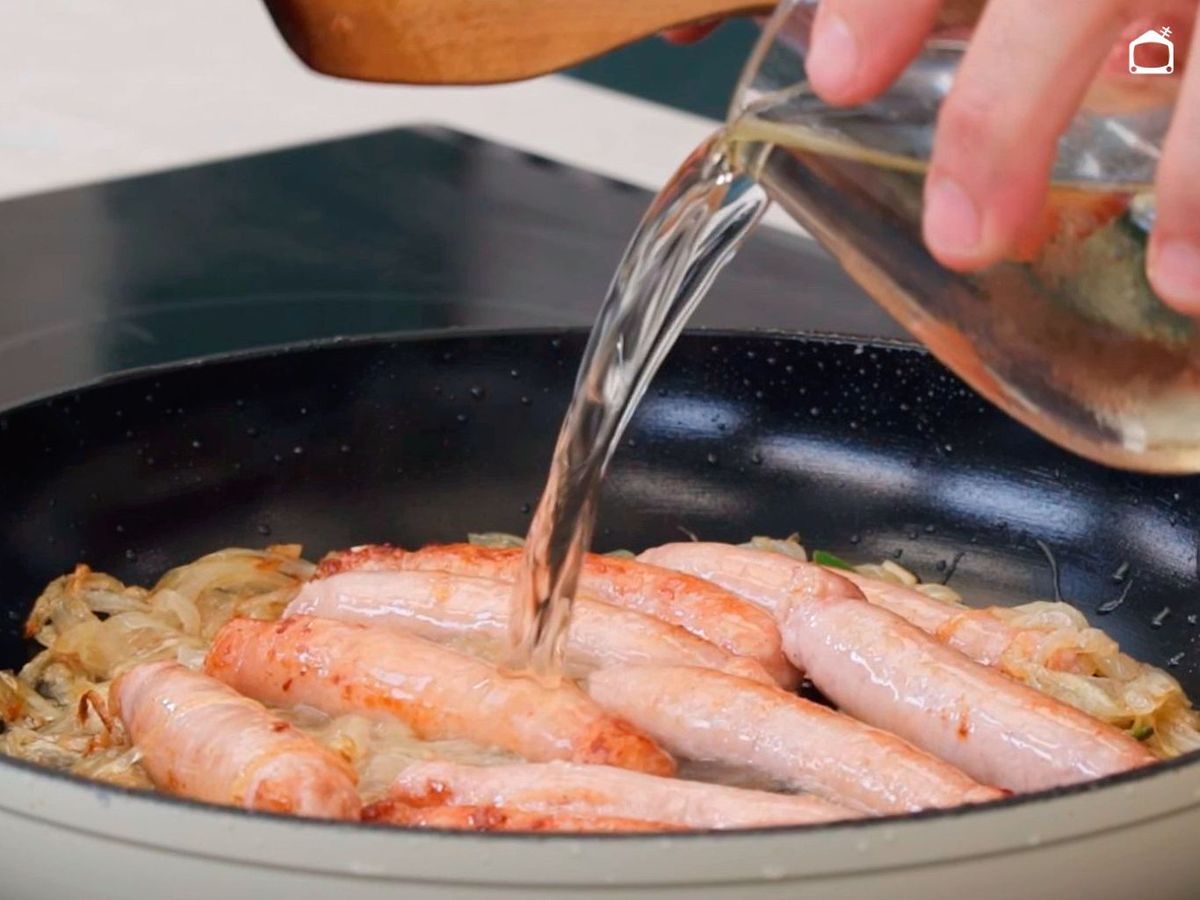 Añadir el vino a las longanizas con cebolla