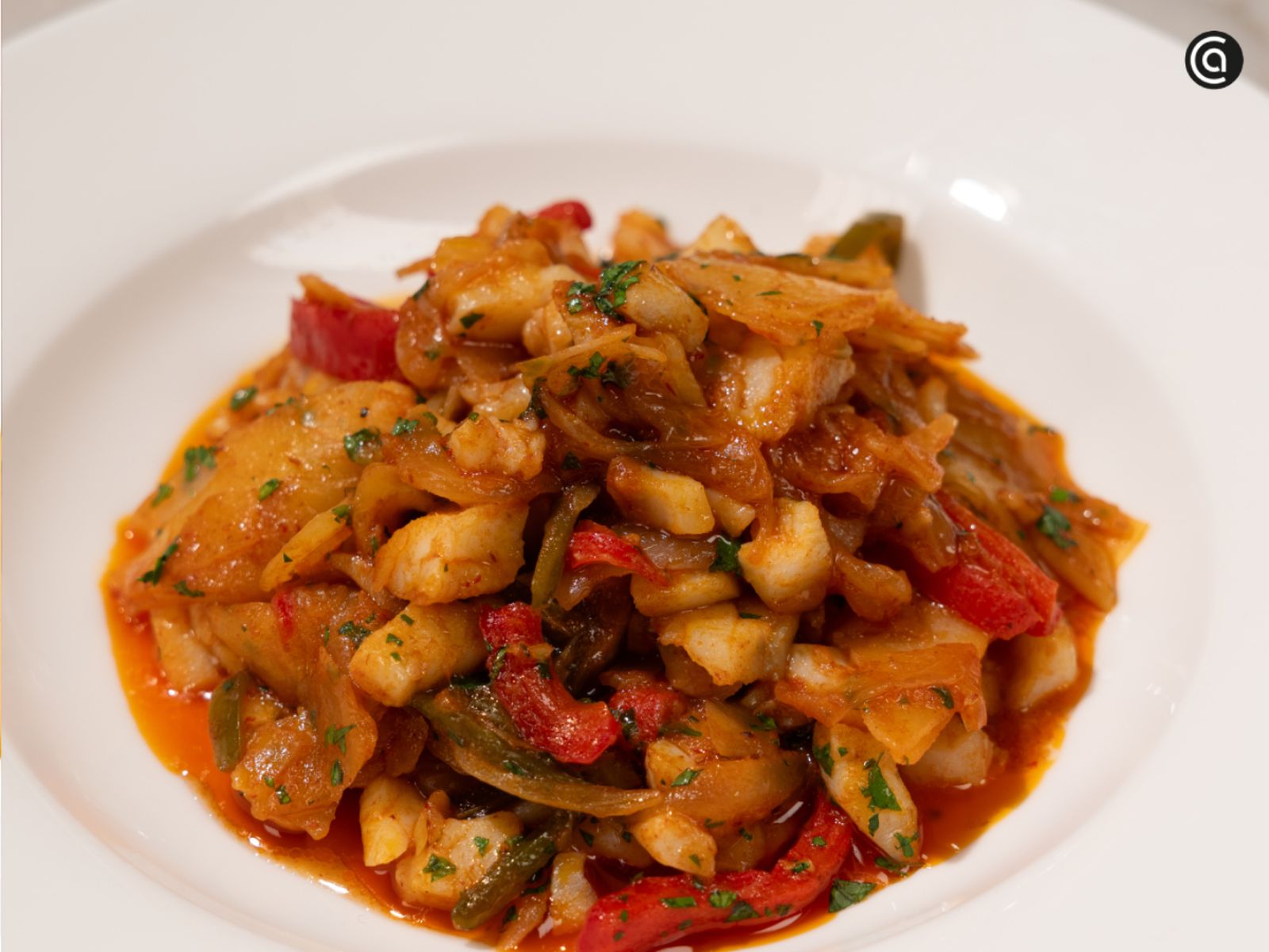 Bacalao al ajoarriero con verduras, patata y una salsa bien ligada, listo para servir bien caliente.