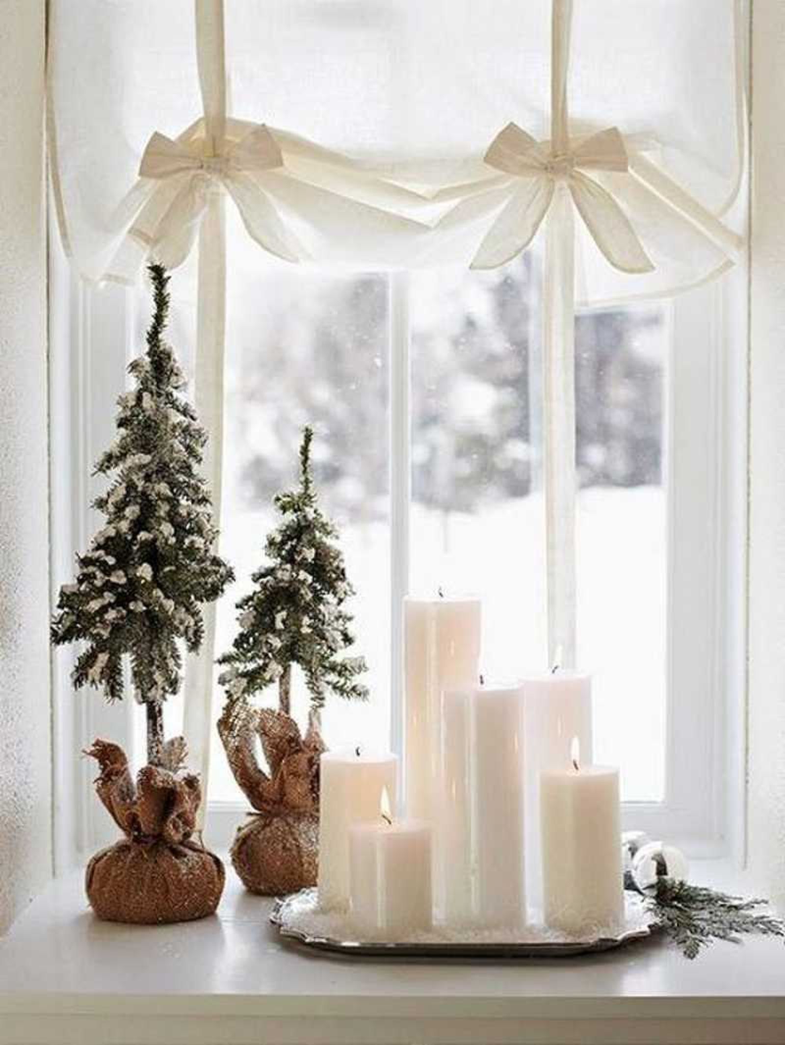 Ventana decorada con velas y mini árboles de Navidad. Ventana decorada con velas y mini árboles de Navidad.